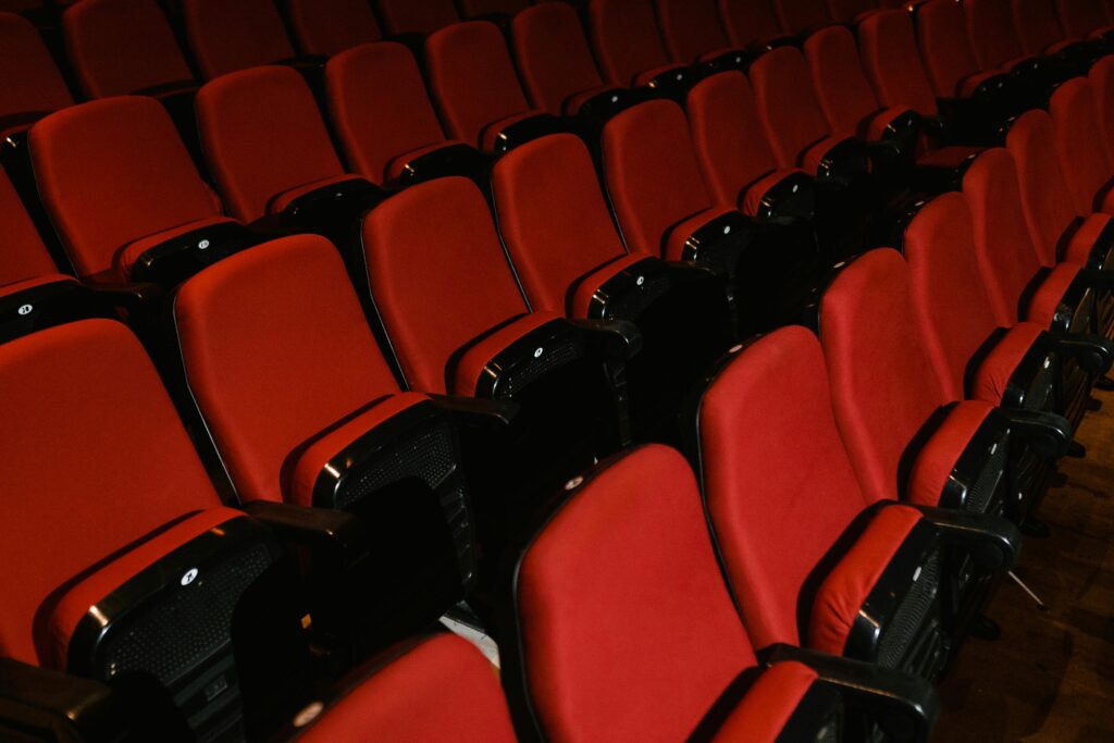 Home Empty rows of red seating in a modern indoor cinema or auditorium, ready for use.